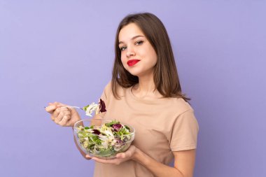 Mor arka planda salata tutan genç kız.