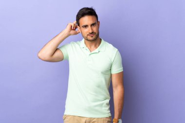 Mor arka planda izole edilmiş genç yakışıklı adamın şüpheleri var.