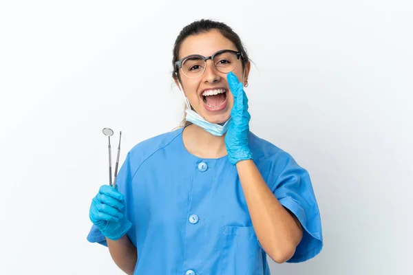 年轻的女牙医拿着用白色背景隔离的工具大喊着 张大嘴 — 图库照片