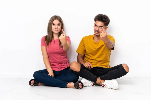 Young Couple Sitting Floor Isolated White Background Doing Coming Gesture — Stock Photo, Image