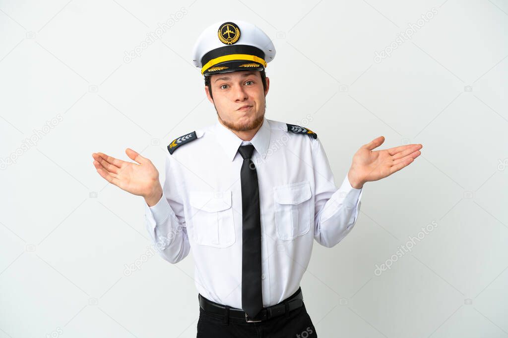 Airplane Russian pilot isolated on white background having doubts while raising hands