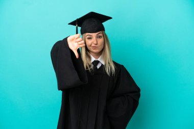 Tecrit edilmiş mavi arka planda genç üniversite mezunu.