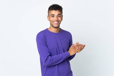 Genç Brezilyalı adam beyaz arka planda izole edilmiş alkışlıyor.