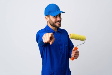 Ressam elinde beyaz arka planda izole edilmiş bir boya silindiri tutuyor ve mutlu bir ifadeyle öne bakıyor.