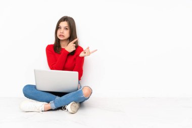 Polisle çalışan hassas kız beyaz arka planda izole edilmiş korkmuş ve kenarı işaret ediyor.