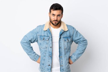 Sakallı yakışıklı genç adam beyaz arka planda izole edilmiş kızgın.