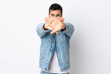 Beyaz arka planda sakallı genç yakışıklı bir adam bir hareketi durdurmak için eliyle jest yapıyor.