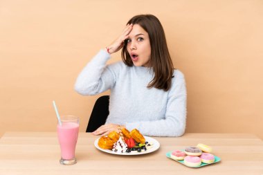 Bej arka planda izole edilmiş waffle yiyen genç kız bir şeyin farkına vardı ve çözüme niyetlendi.