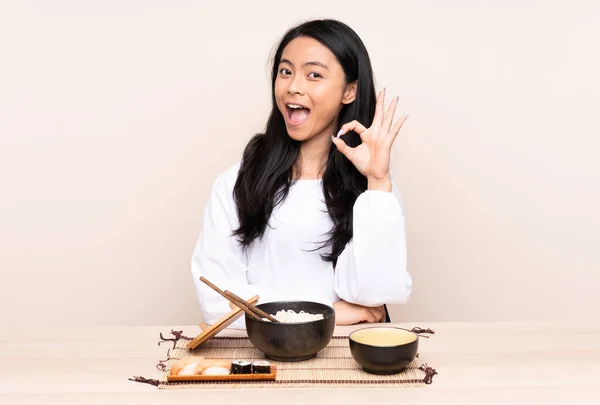 Teenager Ασιάτισσα Κοπέλα Τρώει Ασιατικό Φαγητό Απομονωμένο Μπεζ Φόντο Έκπληκτος — Φωτογραφία Αρχείου