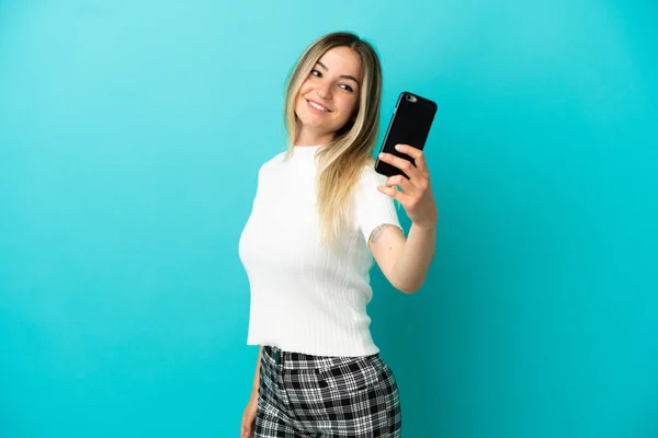 Mujer Joven Sobre Fondo Azul Aislado Haciendo Una Selfie — Foto de Stock