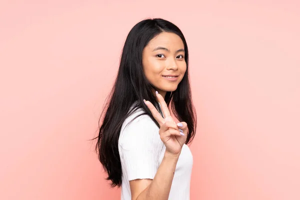 Teenager Chinesin Auf Rosa Hintergrund Isoliert Lächelnd Und Mit Siegeszeichen — Stockfoto