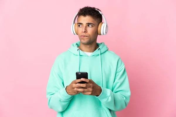 Jeune Homme Brésilien Isolé Sur Fond Rose Écoutant Musique Avec — Photo