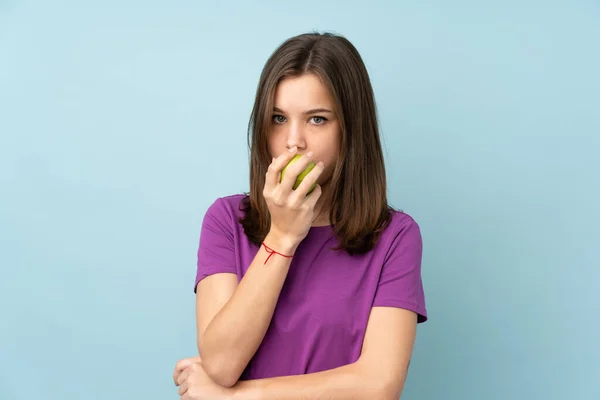 Teenager Mädchen Isoliert Auf Blauem Hintergrund Isst Einen Apfel — Stockfoto