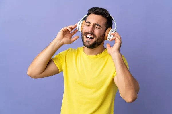 Νεαρός Όμορφος Άντρας Γενειάδα Απομονωμένος Μωβ Φόντο Ακούγοντας Μουσική Και — Φωτογραφία Αρχείου