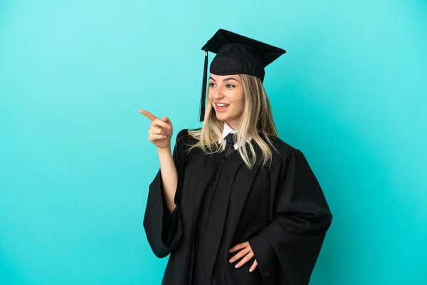 Young University Graduate Isolated Blue Background Pointing Finger Side Presenting — Stock Photo, Image