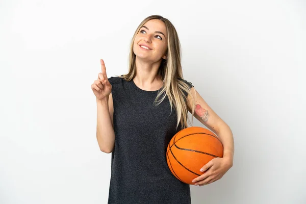 Młoda Kobieta Gra Koszykówkę Nad Odizolowaną Białą Ścianą Wskazując Świetny — Zdjęcie stockowe