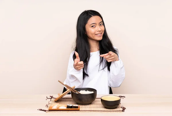 Tiener Aziatische Meisje Eten Aziatisch Eten Geïsoleerd Beige Achtergrond Wijzend — Stockfoto