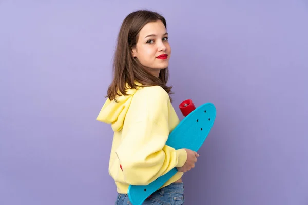 Tiener Meisje Geïsoleerd Paarse Achtergrond Met Een Skate — Stockfoto