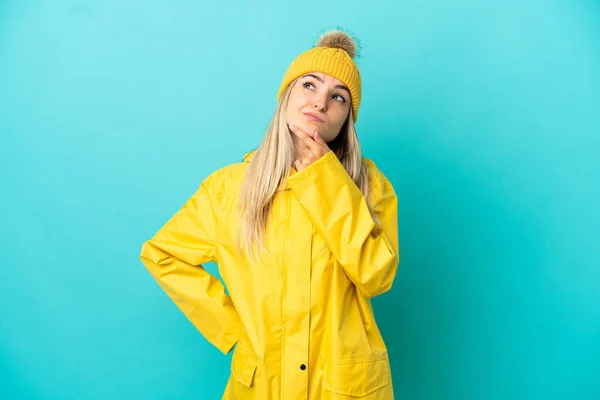 Mujer Joven Con Abrigo Impermeable Sobre Fondo Azul Aislado Que —  Fotos de Stock