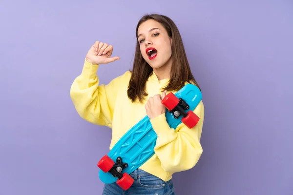 Tiener Meisje Geïsoleerd Paarse Achtergrond Met Een Skate Met Vrolijke — Stockfoto