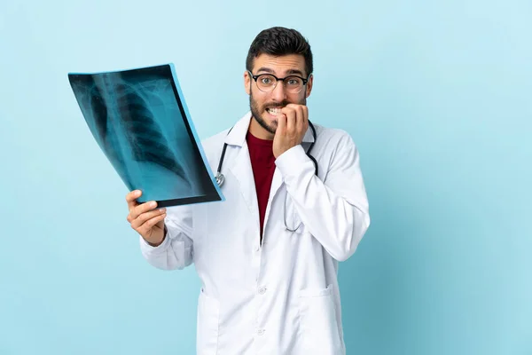 Επαγγελματική Τραυματολόγος Κρατώντας Ακτινογραφία Απομονώνονται Μπλε Φόντο Νευρικό Και Φοβισμένο — Φωτογραφία Αρχείου