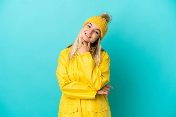 Jovem Mulher Vestindo Casaco Prova Chuva Sobre Fundo Azul Isolado — Fotografia de Stock