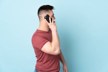 Tecrit edilmiş Rus yakışıklı bir adam cep telefonuyla sohbet ediyor.