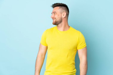 Rus yakışıklı adam mavi arka planda izole edilmiş görünüyor.