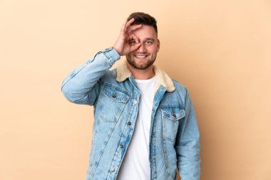 İzole edilmiş arka planda Rus yakışıklı adam parmaklarıyla işaret veriyor.