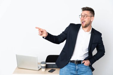 Beyaz arka planda izole edilmiş bir ofiste Rus bir adam parmak işareti yapıyor ve bir ürün sunuyor.