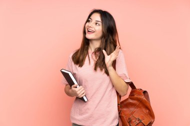 Üniversiteye giden genç bir kız öğrencinin yüzü şaşılacak şekilde pembe arka planda.