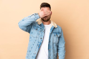 İzole edilmiş geçmişi olan yakışıklı Rus bir adam gözleri elleriyle kapatıyor. Bir şey görmek istemiyorum.