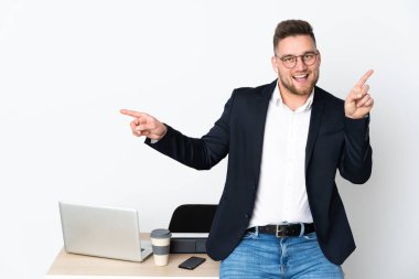 Beyaz arka planda izole edilmiş bir ofiste Rus bir adam parmak uçlarını işaret ediyor ve mutlu.
