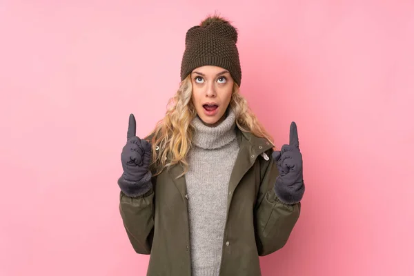 Giovane Ragazza Con Cappello Invernale Isolato Sfondo Rosa Che Punta — Foto Stock