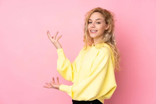 Jovem Loira Vestindo Uma Camisola Isolada Fundo Rosa Estendendo Mãos — Fotografia de Stock