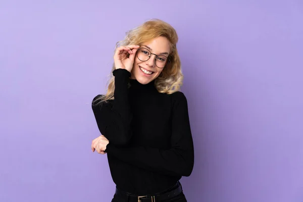 Mor Arka Planda Gözlüklü Mutlu Genç Sarışın Kadın — Stok fotoğraf