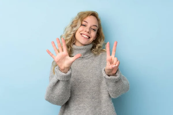 Jovem Loira Vestindo Uma Camisola Isolada Fundo Azul Contando Sete — Fotografia de Stock