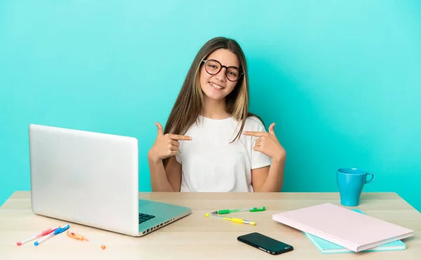 Menina Uma Mesa Com Laptop Sobre Fundo Azul Isolado Orgulhoso — Fotografia de Stock