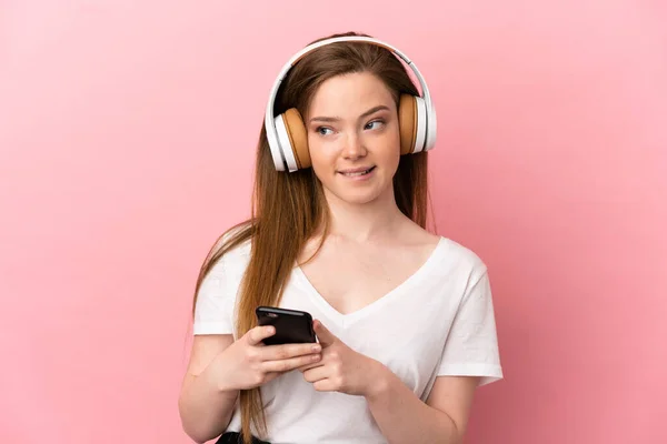 Adolescente Sur Fond Rose Isolé Écoutant Musique Avec Mobile Pensant — Photo