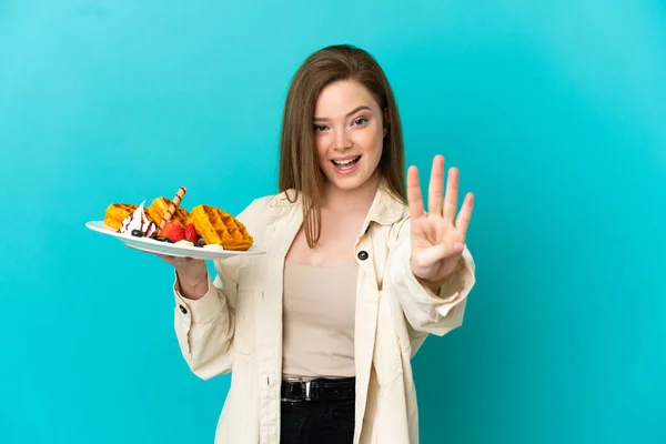 Teenager Mädchen Hält Waffeln Über Isoliertem Blauen Hintergrund Glücklich Und — Stockfoto