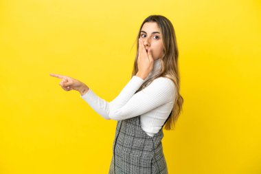 Sarı arka planda izole edilmiş beyaz bir kadın. Sürpriz bir ifadeyle.