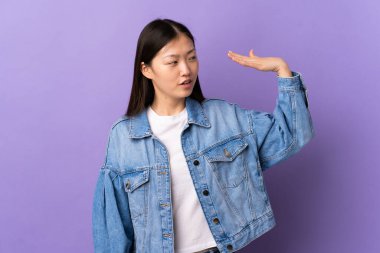 Genç Çinli bir kız, soyutlanmış mor bir geçmişi var, yorgun ve hasta bir ifadesi var.