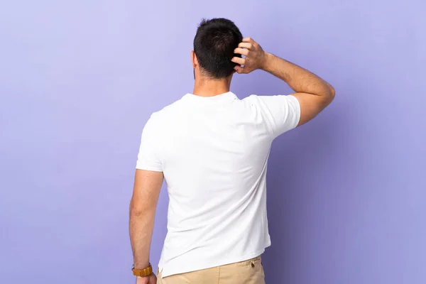 Jovem Homem Bonito Isolado Fundo Roxo Posição Traseira Pensando — Fotografia de Stock