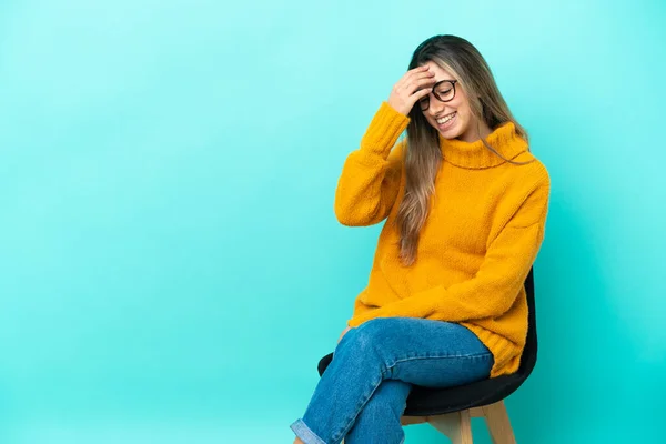 Joven Mujer Caucásica Sentada Una Silla Aislada Sobre Fondo Azul —  Fotos de Stock