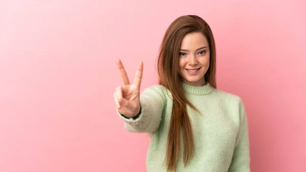 Teenager Mädchen Auf Isoliertem Rosa Hintergrund Lächelt Und Zeigt Siegeszeichen — Stockfoto