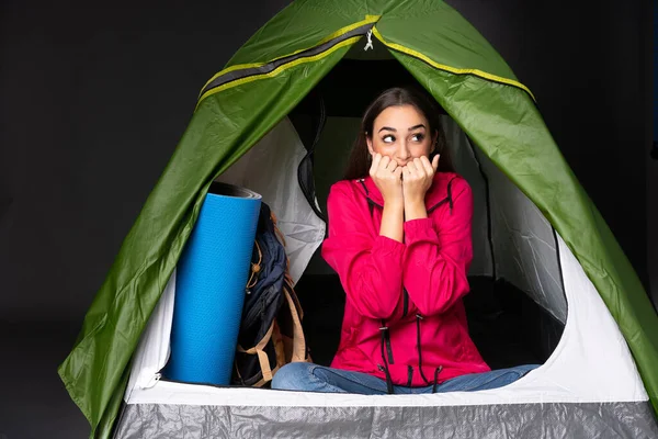 若いですCaucasian女性の中にキャンプ緑のテント緊張と恐怖口に手を置く — ストック写真