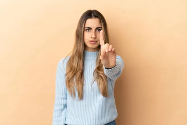 Jovem Caucasiana Isolada Fundo Bege Contando Uma Com Expressão Séria — Fotografia de Stock