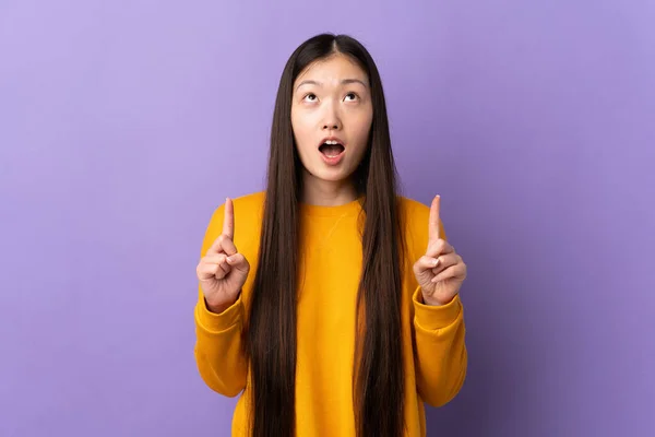 Joven Chica China Sobre Aislado Púrpura Fondo Sorprendido Apuntando Hacia —  Fotos de Stock