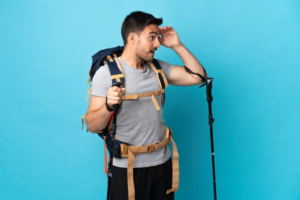 Jovem Caucasiano Com Mochila Postes Trekking Isolados Fundo Azul Com — Fotografia de Stock