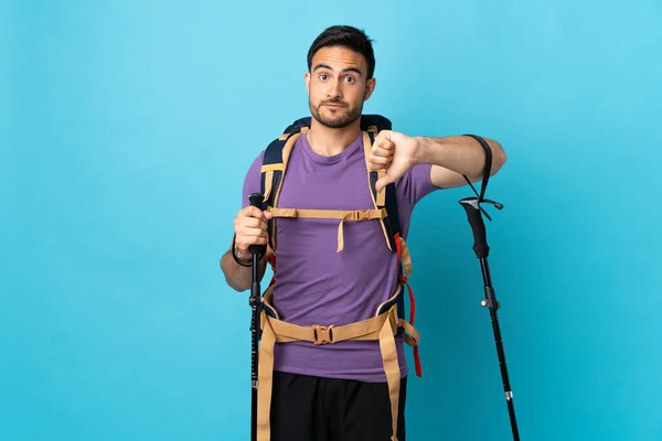 Young Caucasian Man Backpack Trekking Poles Isolated Blue Background Showing — Stock Photo, Image